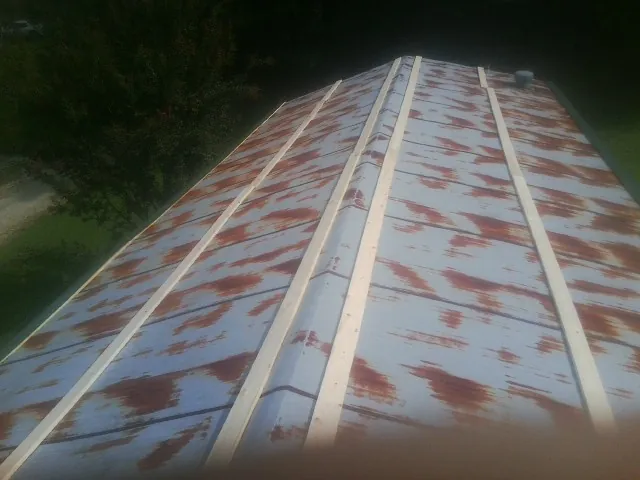 Rusted metal roof panels with new wood purlins before replacement — Storm Damage Roof Repair in White City by Roofing Brothers